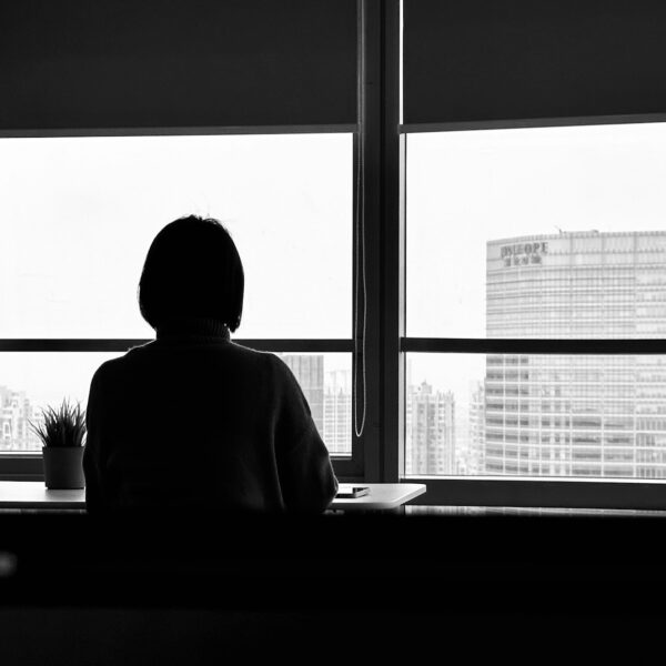 a person sitting in front of a window looking out