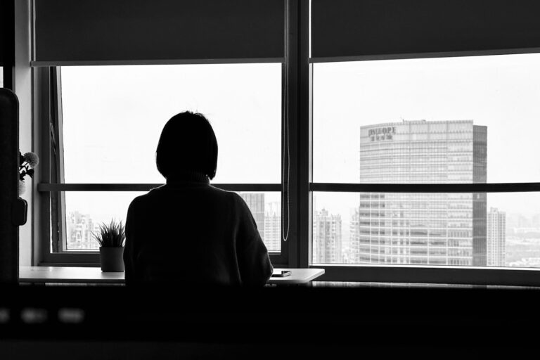 a person sitting in front of a window looking out
