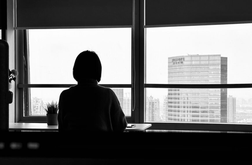 a person sitting in front of a window looking out