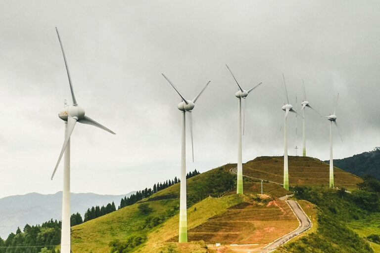 a group of wind turbines on a hill