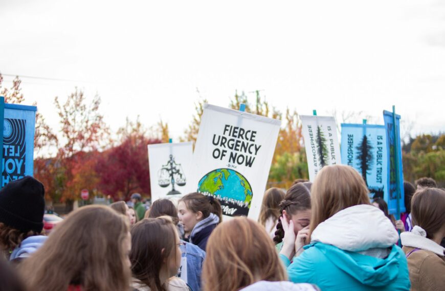 group of people holding signages under white sky