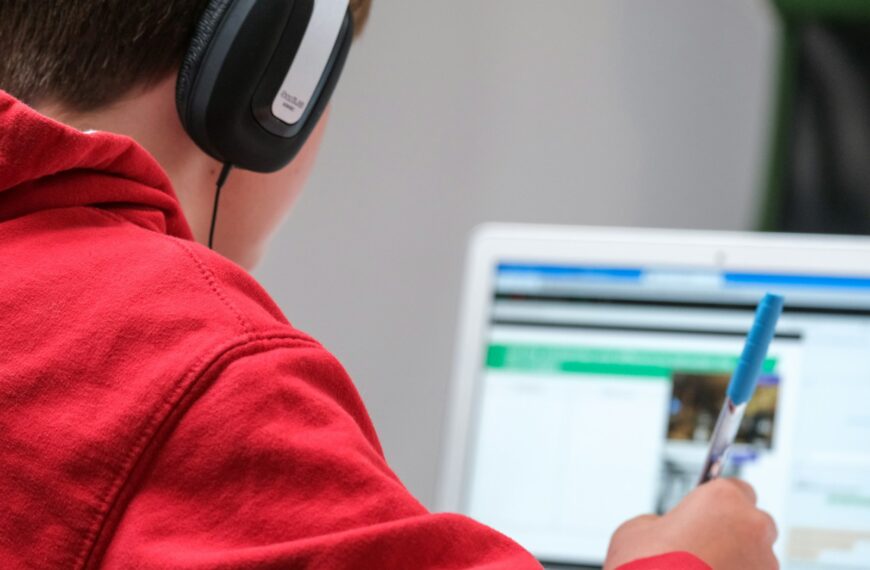 person in red shirt wearing black and gray headphones