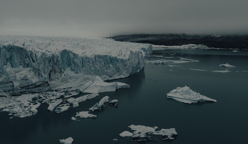a body of water with ice and snow on the shore