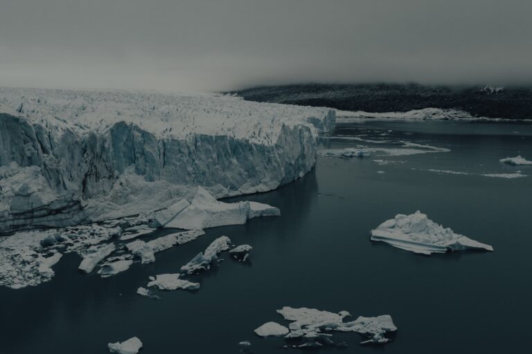 a body of water with ice and snow on the shore