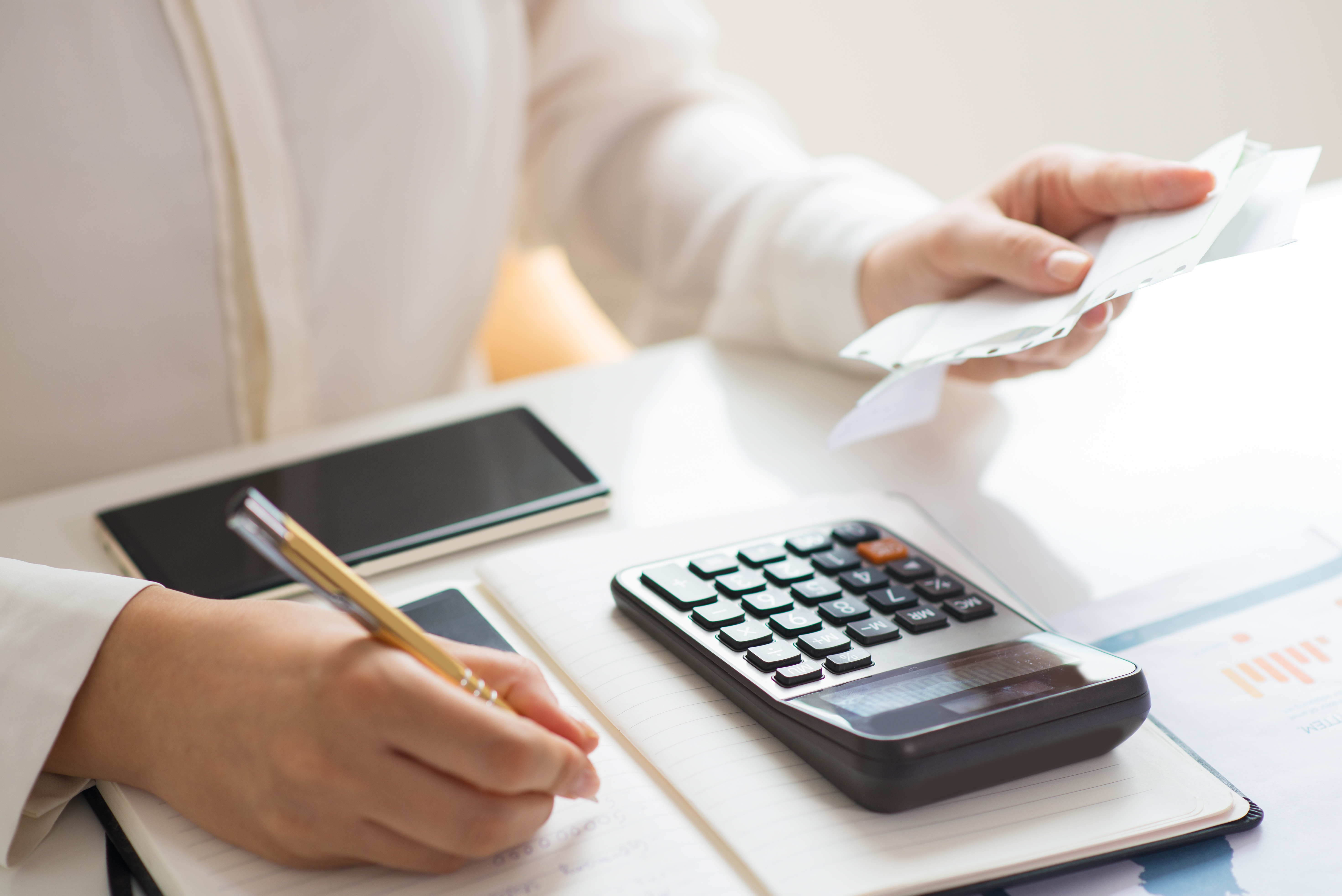 Person reviewing bills and calculating expenses for public procurement